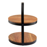 A two-tier display stand crafted from acacia wood with black metal rims and a vertical black handle. Each circular tier showcases visible wood grain, while the handle connects the tiers and extends above for easy carrying or elegant display.