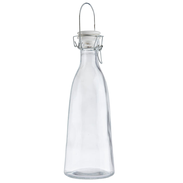 A clear, empty glass carafe with a narrow neck, curved body, and a metal swing-top closure with a white ceramic stopper. The 34 oz carafe stands upright on a white background, and the metal clasp is fastened over the top.