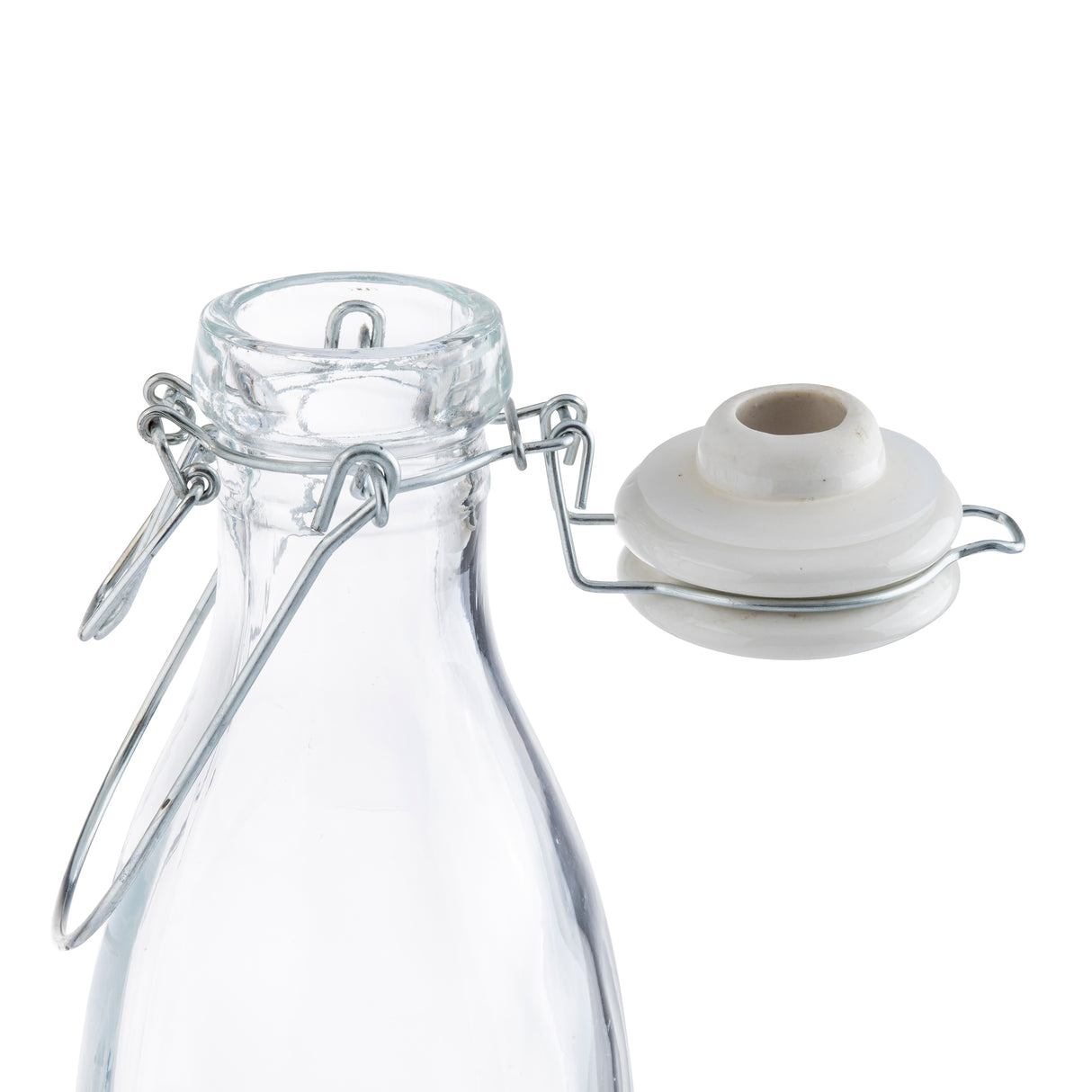 A clear glass carafe with a metal wire swing-top closure. The white ceramic cap with a rubber seal is open and attached to the carafe’s neck by the metal hinge. The background is plain white.