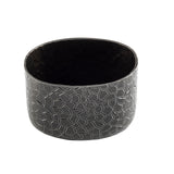 A round, black powder coated aluminum bowl with a glossy interior and a matte exterior featuring an irregular geometric pattern of raised, interlocking lines. Ideal as a modern sugar packet holder with its mosaic-like, textured design.