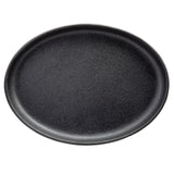 A round, empty black plate with a slightly raised rim, photographed from above against a white background. The plate has a matte, textured surface and resembles a classic TableCraft sizzle platter made of ceramic or stoneware.
