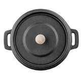 A black cast iron Dutch oven cocotte with a textured lid, round silver knob, and two side handles is shown from above against a white background.