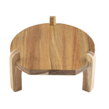 A round wooden platform crafted from light and dark acacia wood with three sturdy legs and a small rectangular handle on top, this TableCraft beverage dispenser stand has a simple, rustic design and is set against a white background.