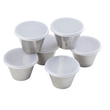Six small 5 oz stainless steel ramekin containers with white plastic lids are arranged in a group on a white background, featuring smooth, reflective surfaces and tightly sealed tops.