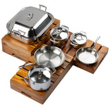 A Signature Cookware Set of five pieces with a sleek stainless steel finish, including pots, pans, and lids, displayed on wooden slatted trays. Features a large covered roasting pan, two saucepans, frying pan, and sauté pan—all with metal handles.