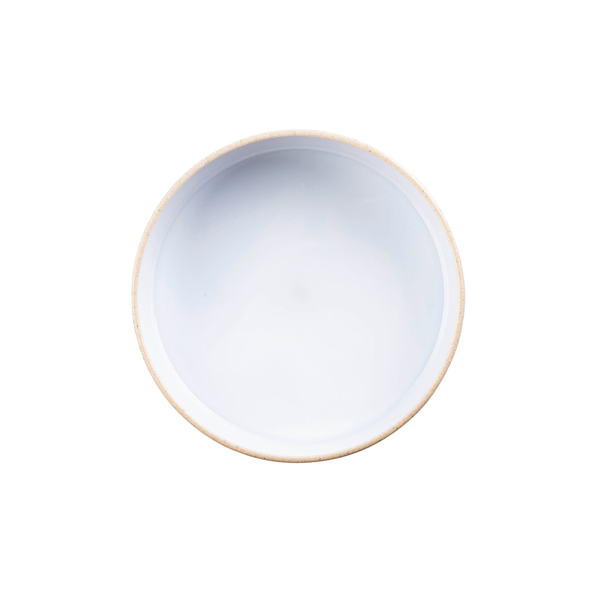 A round, empty ceramic bowl with a white glossy interior and a light beige rim, viewed from directly above against a plain white background, pairs perfectly with any stackable plate for an elegant, organized table setting.