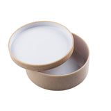 A round, beige bowl with a matching lid, both featuring a smooth, white interior. The stackable container sits on a white background, its lid resting diagonally and partially open to reveal the inside.