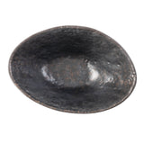 A top-down view of an oval-shaped, dark Lunara Collection Bowl with a slightly uneven rim and textured, matte finish. The bowl appears empty, showcasing its subtle stone pattern as it sits on a white background.