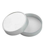 A round, silver-colored metal container with a ridged edge is shown with its lid partially removed at an angle beside the base. The plain white interior suggests it may fit a TableCraft item or serve as a replacement lid. The container appears empty.