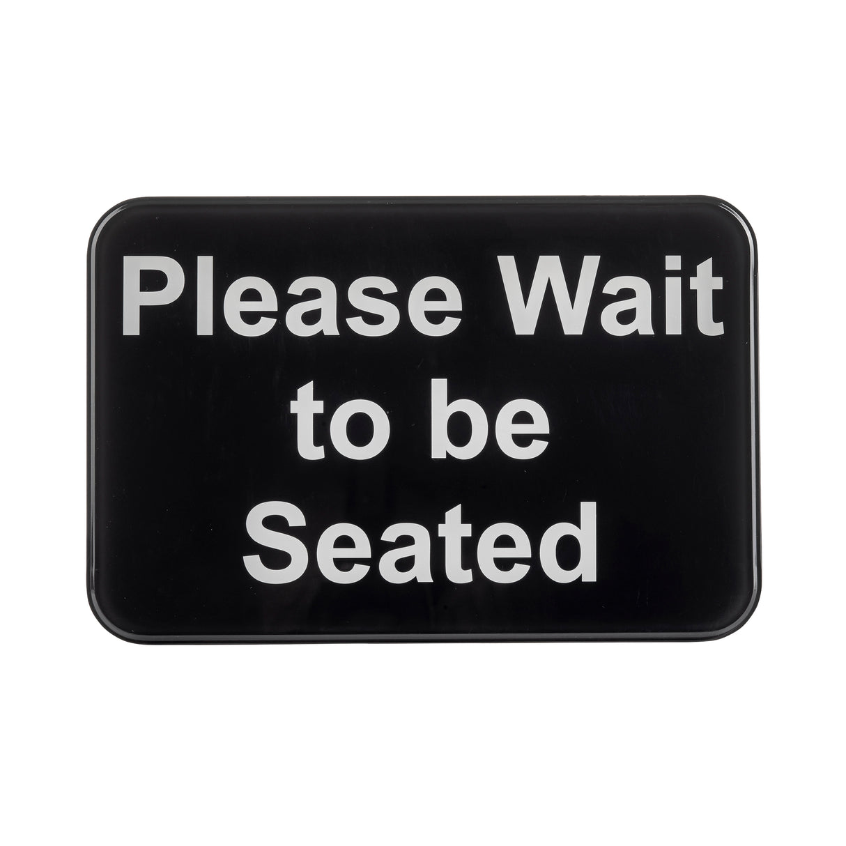 A rectangular black TableCraft 10901 self-adhesive sign with rounded corners displays the white text: “Please Wait to be Seated.” The message is centered, easy to read, and set against a plain background.