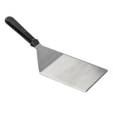 A Heavy Turner metal spatula with a flat, wide stainless steel blade and a black plastic handle. The shiny blade has a slight angle for easy flipping or lifting food. Dishwasher safe and set against a plain white background.