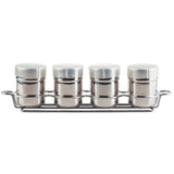 Four identical stainless steel spice jars with white lids are arranged in a row on a matching chrome-plated rack. The cylindrical jars and rack with side handles create a clean, organized look against the white background.