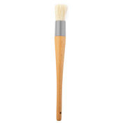 A basting brush with white boar hair bristles, a gray metal ferrule, and a smooth, light brown wooden handle featuring a small hole near the end for hanging, shown against a white background.