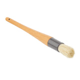 A wooden-handled pastry brush with light-colored, soft boar hair bristles and a dark metal ferrule. The smooth, slightly tapered handle features a small hanging hole. The brush is positioned diagonally on a white background.