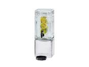 A clear, rectangular BPA free beverage dispenser filled with water and several lemon and lime slices. The dispenser has a black spigot in the center for pouring and a matching black lid at the base, all set against a plain white background.
