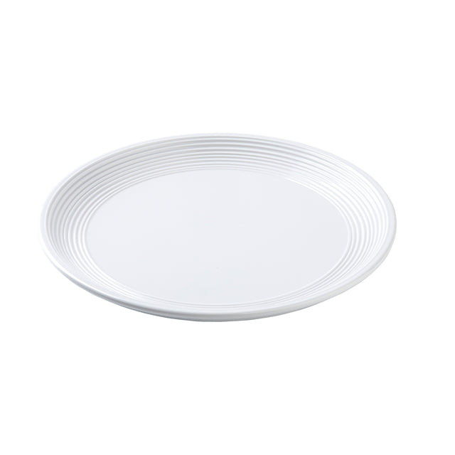 A plain white round plate with a smooth surface and subtle concentric ridges along the outer rim, photographed against a white background. The Pulito Collection Plate is empty and seen from a slight angle.