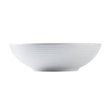 A white ceramic Pulito Collection bowl with a wide, shallow shape and horizontal ridges encircling the exterior. The bowl has a slightly raised, narrow base and a smooth, minimalist design. The background is plain white.