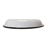 A white, shallow, round enamelware plate from TableCraft Products with a raised rim and thin black edge is shown upside down against a plain white background, highlighting its gently sloping dome-like shape.