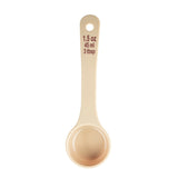 A beige polycarbonate measuring spoon viewed from above, showing measurement markings in red text: “1.5 oz, 45 ml, 3 tbsp.” The NSF-listed spoon is clean and features a circular handle hole at the top for hanging or storage.