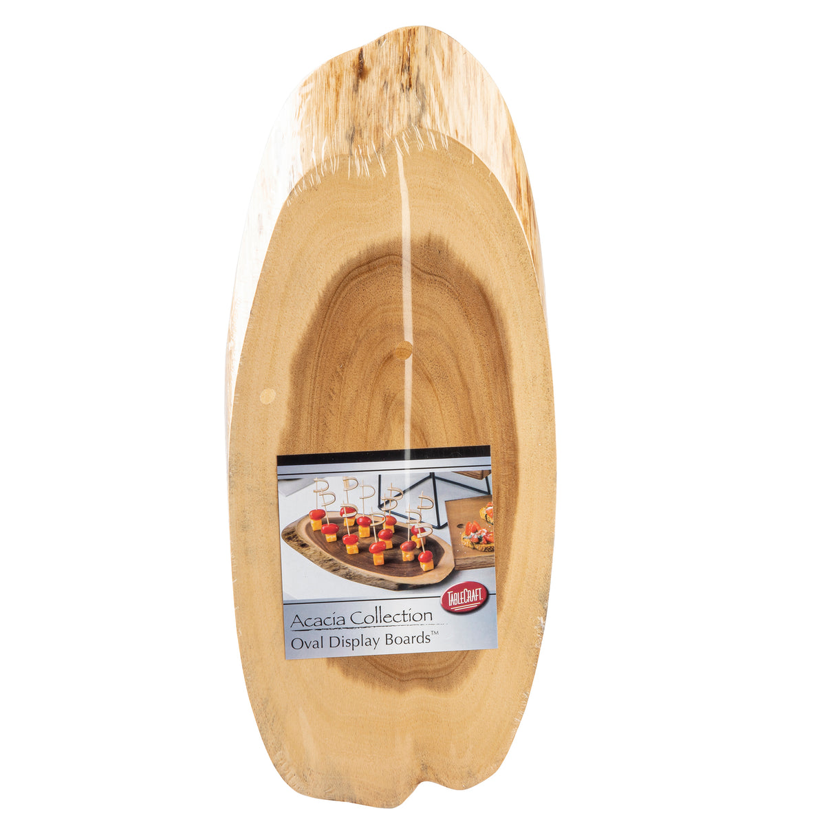 An oval Acacia Serving Board from TableCraft Products is displayed vertically, still in plastic wrap. A label reads "Acacia Collection Oval Display Boards" and features appetizers arranged on a similar Wood Serving Board.