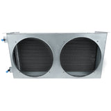 Rectangular metal air conditioning unit housing with two large circular cutouts on the front, exposing black finned condenser coils inside. Blue plastic caps likely cover Empura Refrigeration pipe connections. The background is white.