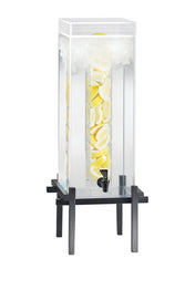 A tall, clear 5 gallon beverage dispenser filled with water and sliced lemons. The dispenser has a black spigot near the bottom and stands on a black metal frame with four legs. Crushed ice is piled on top inside the infusion chamber.