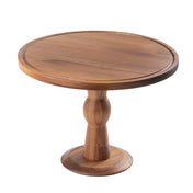 A round wood cake stand with a smooth surface and natural brown finish, featuring a wide, flat top and sturdy pedestal base. This Acacia cake plate by TableCraft sits on a small, circular foot and is isolated on a white background.
