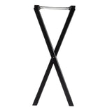 A black, metal tray stand is shown standing upright in an X shape. The stand features two intersecting legs and a horizontal support bar at the top for holding luggage or trays. The background is plain white. Ideal for TableCraft serving needs.