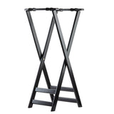A black rubberwood luggage rack with a foldable X-frame design, two flat support bars on top, and two horizontal bars near the base for stability. The smooth surface is empty, making this versatile piece perfect as a tray stand or for guest use.