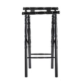 A black rubberwood luggage rack with a spindle design features four turned legs, two woven support straps across the top, and decorative grooves along the legs, viewed from the front against a white background.