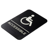 A rectangular black accessible sign made of durable polystyrene displays a white wheelchair symbol above “ACCESSIBLE” in bold letters, separated by a line. Braille dots below ensure accessibility for visually impaired individuals.