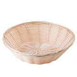 A light-colored, round hand-woven wicker basket with a flat base and shallow, wide sides. The basket features an open-weave pattern and a smooth, slightly scalloped rim, set empty against a plain white background.