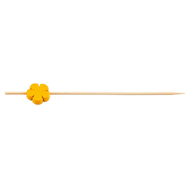 A natural bamboo pick with a small, orange, flower-shaped decoration near the blunt end. These decorative picks from TableCraft Products feature a pointed tip and are set against a plain white background.