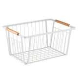 A white powder coated steel storage basket with an open grid design and two wooden handles attached to the top edges. The empty basket is set against a plain white background.