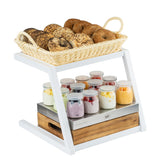 A grab and go frame display stand holds a wicker basket of assorted bagels on top and twelve glass jars of yogurt with fruit on the lower shelf. The white, powder coated steel frame features a wooden tray, with a plain white background.