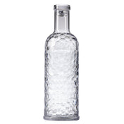 A clear, textured TableCraft carafe with a cylindrical body and narrow neck, filled with water. The 34 oz bottle features a faceted geometric pattern and is sealed with a transparent, flat-topped cap, standing upright on a plain white background.