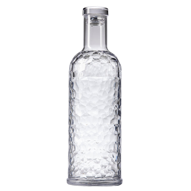 A clear, textured TableCraft carafe with a cylindrical body and narrow neck, filled with water. The 34 oz bottle features a faceted geometric pattern and is sealed with a transparent, flat-topped cap, standing upright on a plain white background.