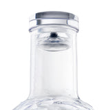 Close-up of a transparent TableCraft 34 oz carafe with a silver and clear plastic cap. The neck is covered in condensation, highlighting its cold, sleek, modern design against a plain white background.