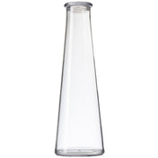 A clear, empty, 34 oz tall glass carafe with smooth sides tapers gently inward from a wide base to a narrow, round opening at the top. This elegant TableCraft vessel stands upright against a plain white background.
