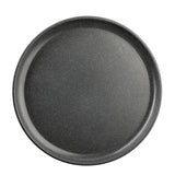 A round, black, non-stick pizza pan with a slightly raised edge and a speckled pattern, photographed from above against a white background. Reminiscent of the TableCraft Products Terra Collection Serving Plate, its surface appears smooth and clean.