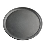 A round, dark gray pizza pan from the Terra Collection features a slightly raised edge and a smooth, matte finish. Subtle speckling hints at a non-stick coating. The pan is photographed from above on a plain white background, like a serving plate.