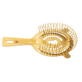 A gold stainless steel cocktail strainer with a flat handle and coiled spring fits shaker tins for smooth straining. The reflective surface and rectangular cutout on the handle add both style and function.