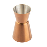 A TableCraft stainless steel jigger for measuring alcohol, featuring a shiny silver interior and brushed copper-colored exterior. Its hourglass shape with two conical sections offers precision, and it’s displayed on a white background.