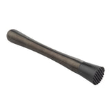 A black cocktail muddler with a smooth handle that tapers towards a flat, textured end featuring raised ridges for better grip on herbs or fruit. This gunmetal muddler is placed on a white background.