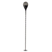 A long, thin stainless steel Bar Spoon with a twisted shaft stands upright on a small round base. The top features a large, teardrop-shaped paddle, blackened at the edges and fading to metallic grey. The background is plain white.