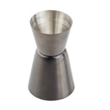 A gunmetal stainless steel jigger with two conical measuring cups joined at the base, forming an hourglass shape. One side is smaller and the other larger, perfect for measuring liquor or cocktail ingredients. The metal has a brushed finish.