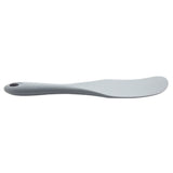 A gray, curved silicone kitchen utensil, shaped like a Solid Spurtle, with a rounded end and a hole at the handle’s base. It rests flat on a white background and looks smooth, ergonomic, and perfect for spreading butter or soft foods.