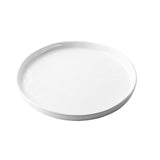 A plain, round, white ceramic plate with a slightly raised edge from the Ridge Collection Serving Plate series, photographed on a white background. The plate is empty and has a smooth, glossy surface.