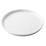 A plain, round white TableCraft Ridge Collection Serving Plate with slightly raised edges, photographed from a slight angle against a white background. The plate’s smooth, glossy surface features no visible patterns or decorations.