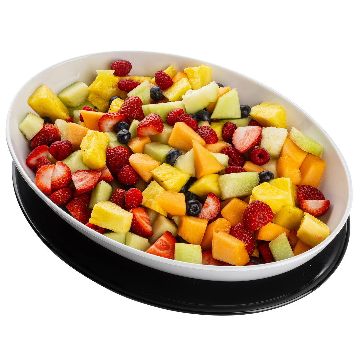 An oval white melamine serving platter from TableCraft Products, filled with assorted fresh fruit—sliced strawberries, cantaloupe, honeydew melon, pineapple chunks, and blueberries—sits on a black tray against a white background.